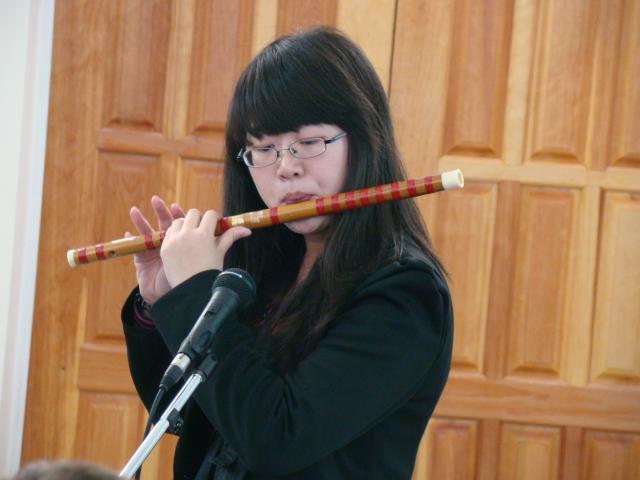 Игра на национальноя китайском инструменте.