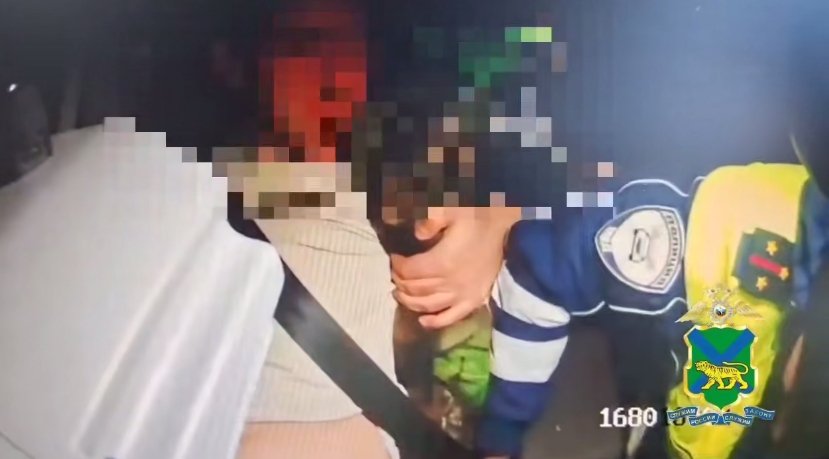 Задержанный мотоциклист в патрульном автомобиле стоп-кадр из видео, размещенном пресс-службой полиции Приморья