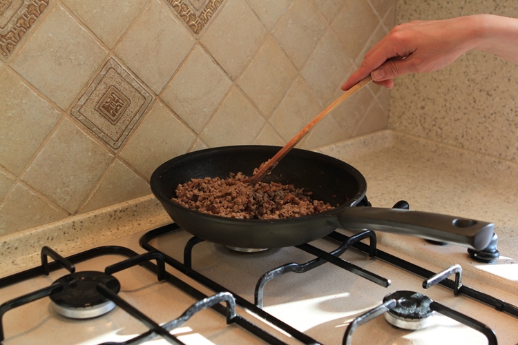 Готовим начинку. Раскалим растительное масло, обжарим лук, грибы, добавим мясной фарш и все хорошенько потушим на среднем огне. Переложим начинку в глубокую миску и дадим остыть